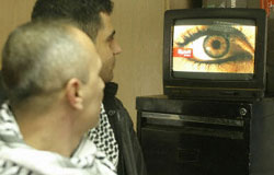 Lebanese men watch the new U.S. government-funded satellite station Al-Hurra