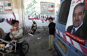 A Palestinian boy holds his bicycle outside a polling station