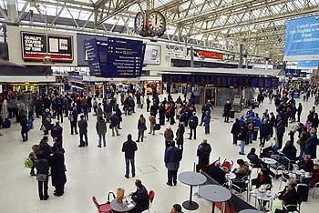 People at Waterloo train station in London pause to observe three minutes of silence
