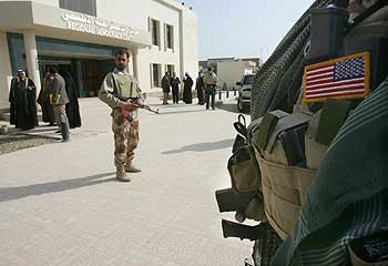 American and Iraqi soldiers stand guard in Hilla