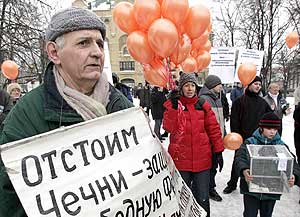 A man holds a poster that says “Defend the freedom of Chechnya”